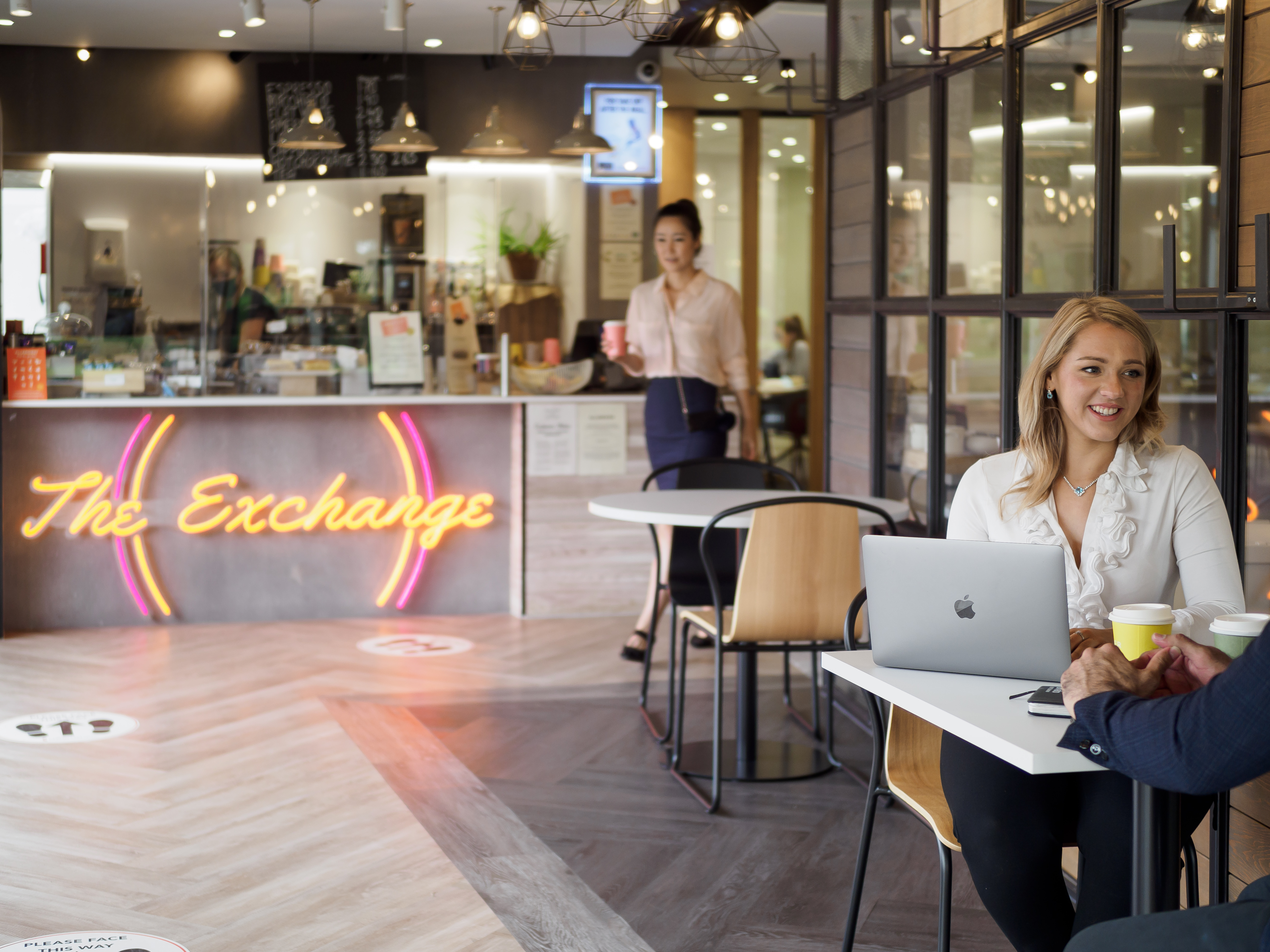 Two people sitting at a table in a coffee shop.