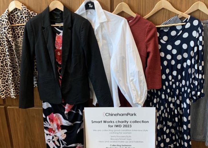 A group of women's clothes hanging on a rack.
