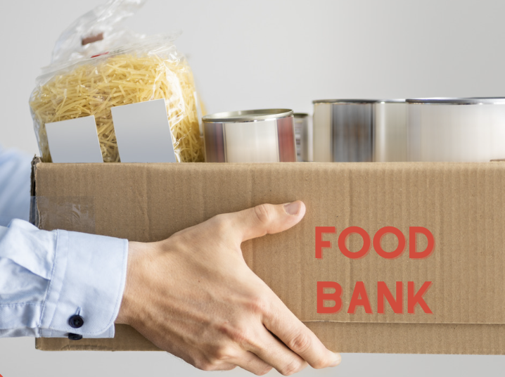 A man holding a cardboard box with food in it.