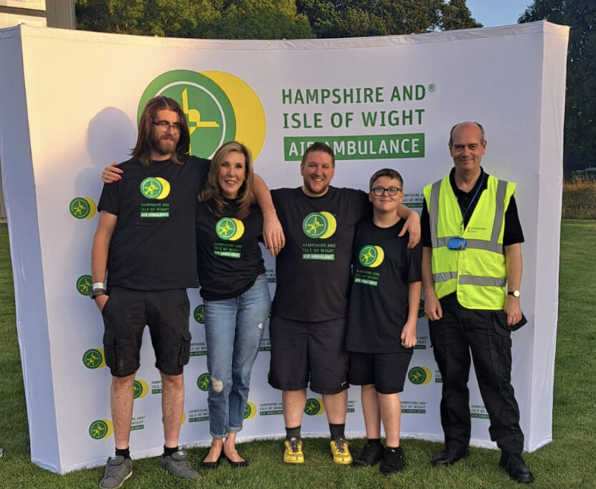 A group of people posing for a photo in front of a sign.