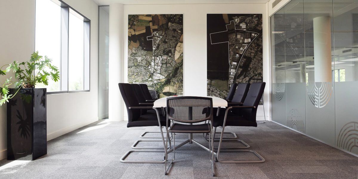 A business park conference room with a table and chairs.