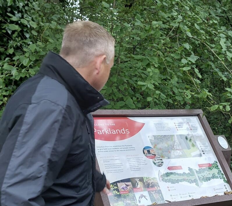 A man looking at a map in the woods.