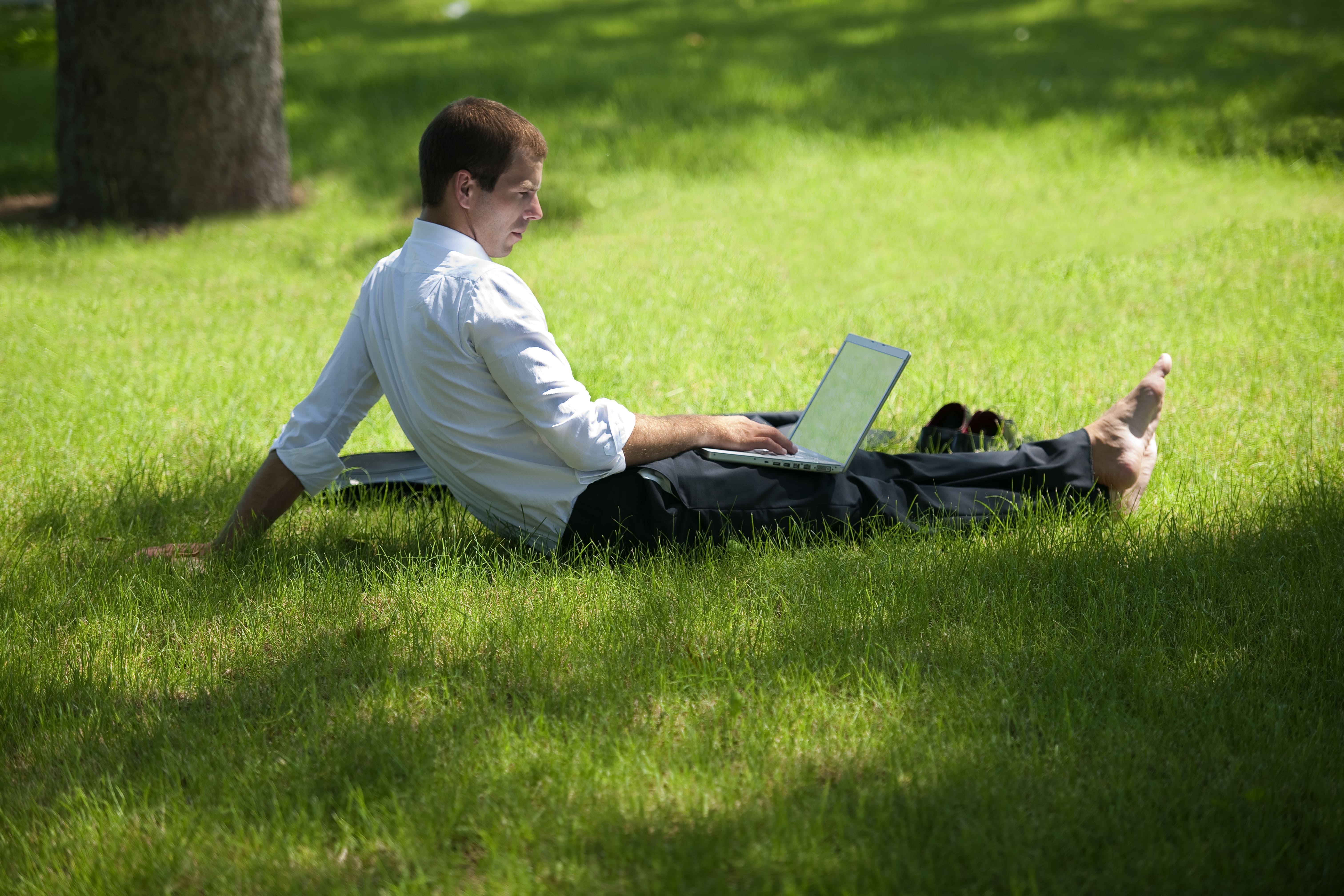 A man on his laptop, working outside
