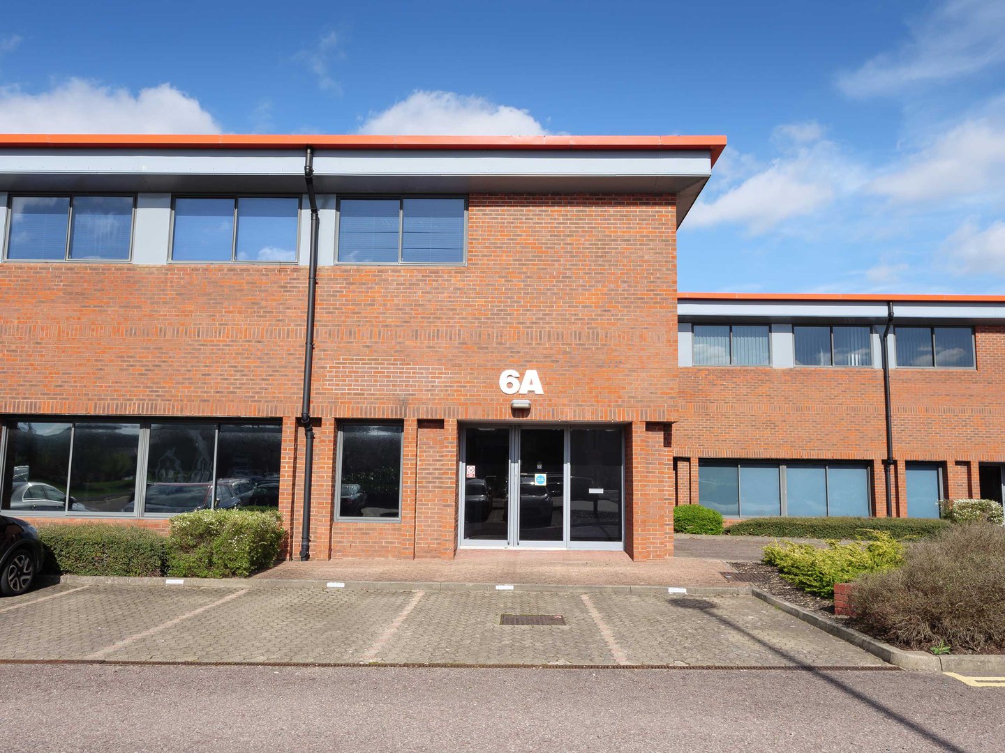 Red brick office building with large windows, labeled 