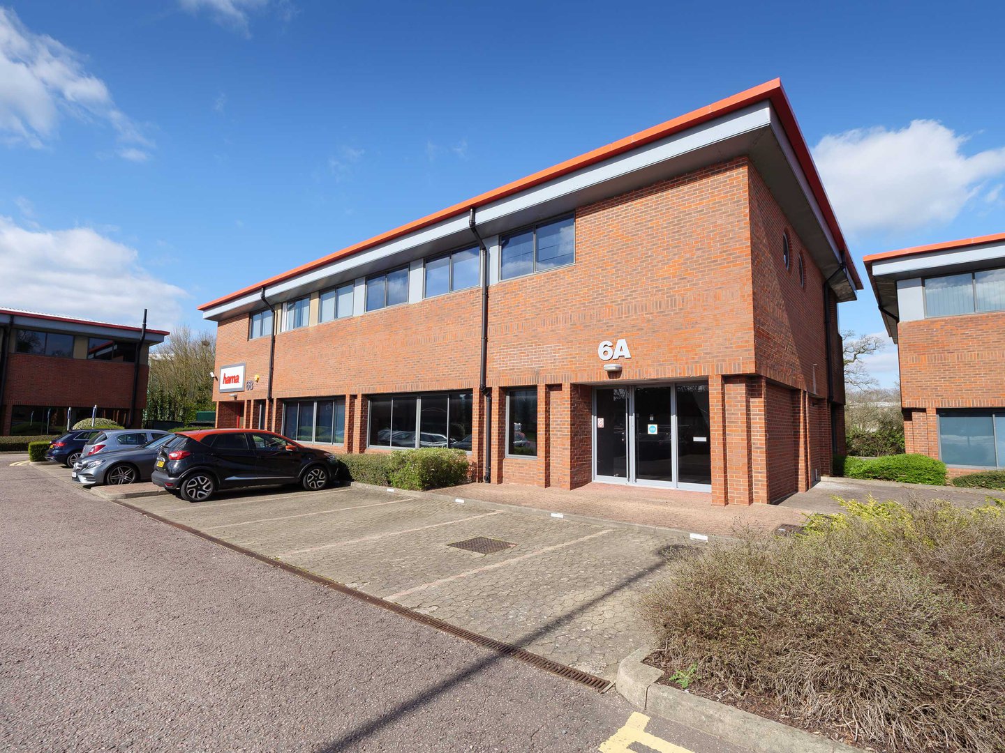 Two-story brick office building with a red trim, labeled 